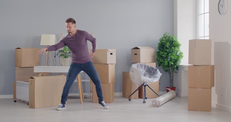 Lively portrait of a joyful man dances amidst the moving process, bringing celebration to relocation to a new home or office. The image captures the positive energy and excitement of the transition.