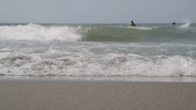Handheld shot of sea waves splashing on shore during summer at beach