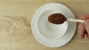 Hand adds instant coffee to a white mug, close-up. Freeze-dried coffee granules dipped into cup with spoon. Coffee break concept, 4k - Powered by Shutterstock - Get 15% off with code: PIKWIZARD15