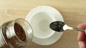 Hand adds instant coffee to a white mug, close-up. Freeze-dried coffee granules dipped into cup with spoon. Coffee break concept, 4k - Powered by Shutterstock - Get 15% off with code: PIKWIZARD15
