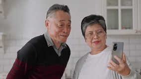 Happy asian senior elderly have fun with smartphone to talk to daughter online wave hand to webcam glad to say hello.Smiling mature male calling,app for video conversations,enjoy family retirement. - Powered by Shutterstock - Get 15% off with code: PIKWIZARD15