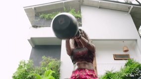 Dynamic crossfit session featuring biethnic woman lifting kettlebell in outdoor setting. Focused athlete performs strength exercise, power, determination. Diversity, fitness blend empowering display. - Powered by Shutterstock - Get 15% off with code: PIKWIZARD15