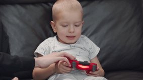 3-year-old child holding video game gamepad, little boy with game controller playing on a game console.