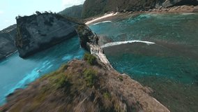 FPV drone flies through the rocks on the beach and flies up to a fishing boat 