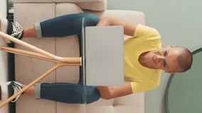 Vertical video, Beautiful smiling woman using laptop while sitting in living room at home