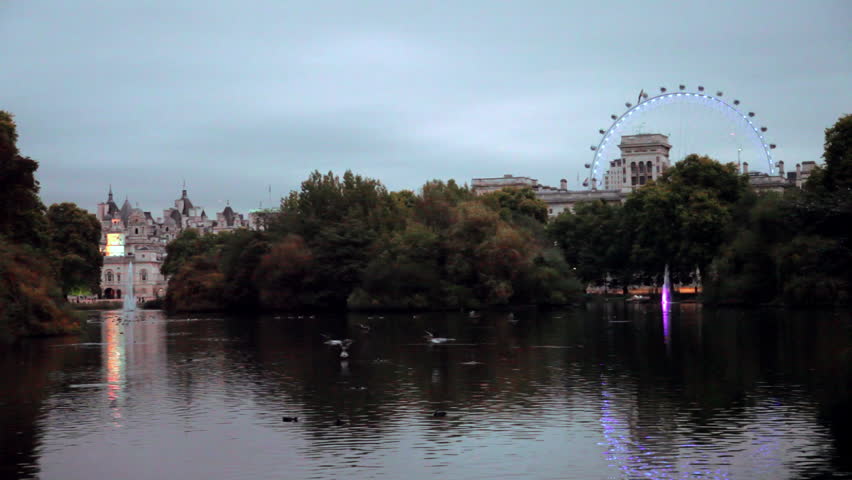 View from a bridge in a park overlooking a building and the London Eye in London