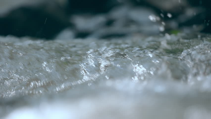 Palm hand touching on clear stream water in the rainforest waterfall. People travel and enjoy with nature. Slow motion shot.
