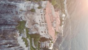 Vertical video. Meteora, Kalabaka, Greece. Monastery of Varlaam. Meteora - rocks, up to 600 meters high. There are 6 active Greek Orthodox monasteries listed on the UNESCO list, Aerial View, Point of