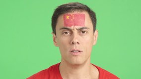 Man with a chinese flag painted on the face smiling