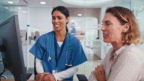 Female doctor or nurse meeting with woman patient for appointment in hospital looking at computer monitor - shot in slow motion - Powered by Shutterstock - Get 15% off with code: PIKWIZARD15