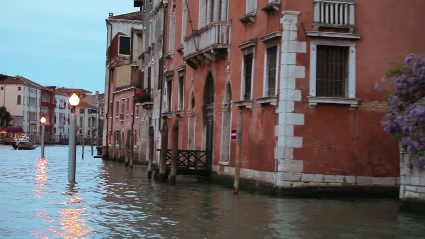 Floating past buildings and lamp posts at dusk on The Venetian Canal