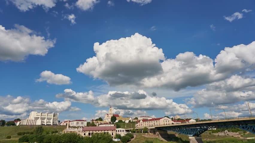 timelapse movement of clouds over the city center. River and bridge in the historical center of the city. Hyperlapse movement of clouds over the old church and the Catholic temple.