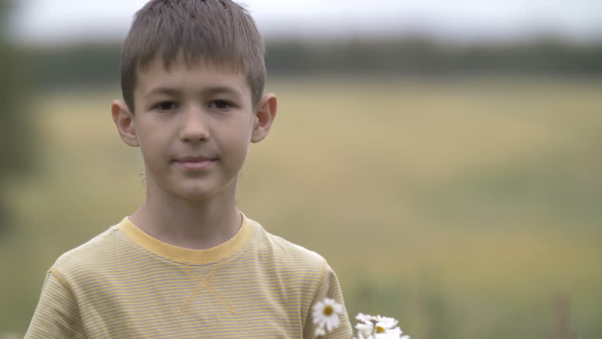 boy with flowers smiling and looking at camera