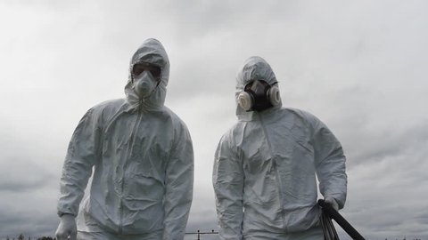 two man in uniform carrying lethal chemical product