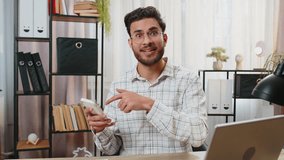 Smiling young businessman using smartphone app online pointing showing like thumbs up remote distance job working from home office. Guy freelancer e-learning texting messages content on social media. - Powered by Shutterstock - Get 15% off with code: PIKWIZARD15