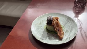 Traditional catalan trinxat de Cerdanya with mashed potatoes and cabbage, pork belly and butifarra sausage served on plate over wooden table. Handheld circular panning and zoom in footage