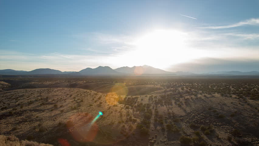 The sun sets behind the San Francisco Peaks and Humphreys Peak in Flagstaff Arizona, as seen from Doney Mountain in the Coconino National Forest.