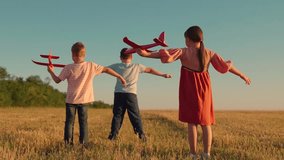 Happy children run with toy plane across field at sunset. Boy, girl wants to become pilot, an astronaut. Children play with toy plane. Slow motion. Teenager dreams of flying, becoming pilot. Children - Powered by Shutterstock - Get 15% off with code: PIKWIZARD15