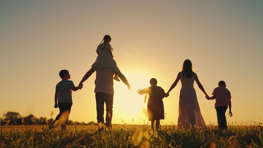 Little daughter on shoulders of Dad, mom, son, walk hand in hand outdoor. Big family, group of people in nature. Happy family with children go across grassy field in summer. Parental care for children