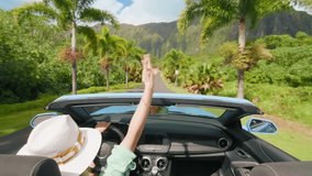 Happy girl in blue convertible car enjoying summer vacation, waiving hand out of the car and showing shaka hawaiian sign. Woman travels by tropical island with tropical exotic mountain landscape Oahu - Powered by Shutterstock - Get 15% off with code: PIKWIZARD15