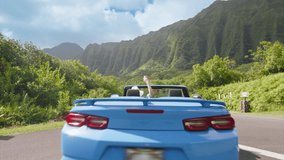 Back view of modern blue convertible car driving away. Driver woman enjoying majestic jungle mountain views. Woman travels Oahu island on summer vacation. Happy tourist in blue convertible car Hawaii - Powered by Shutterstock - Get 15% off with code: PIKWIZARD15