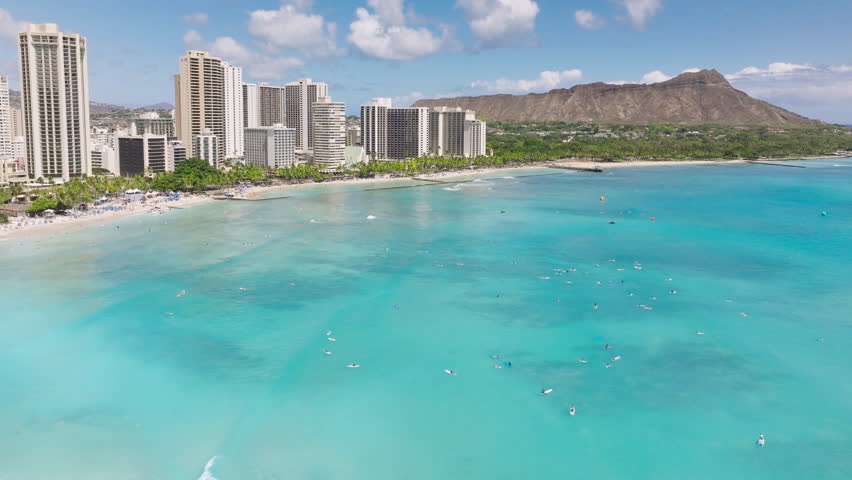 Scenic Diamond head volcano on sunny day. Hawaii vacation at Waikiki beach resorts panorama with blue waters. Aerial beach on tropical exotic Oahu island. Surfers swimming in ocean at modern hotels Royalty-Free Stock Footage #3441529021