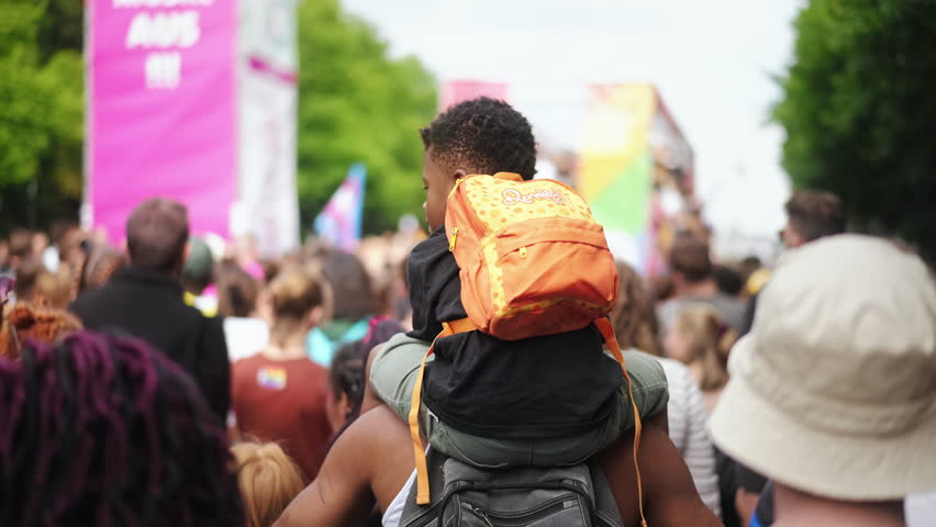 Little kid sit father shoulders. Many gay people protest against racism. Family walk lgbt pride. African american child watch black lives matter strike. Parents show csd day demonstration to boy son.