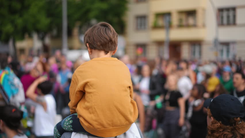 Little kid sit father shoulders. Many gay people crowd protest against homophobia. Family walk lgbt pride parade. Child watch strike demonstration. Parents show csd fest day to boy son. Peaceful rally Royalty-Free Stock Footage #3441600331