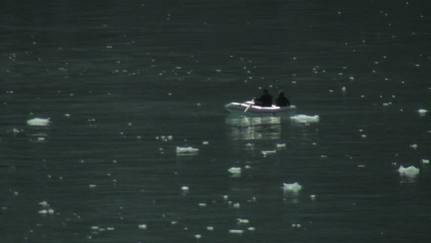 Two people venture out to grab a closer look of the glaciers in a dingy set in Glacier Bay, Alaska