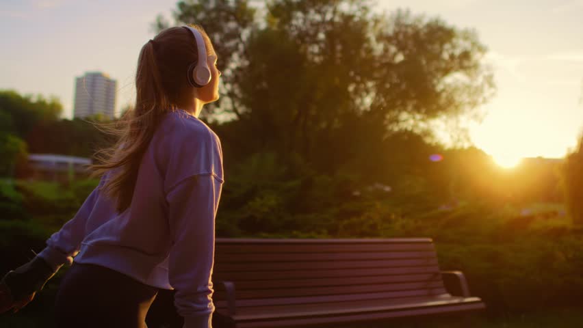 Young woman rollerblading in the park during sunset