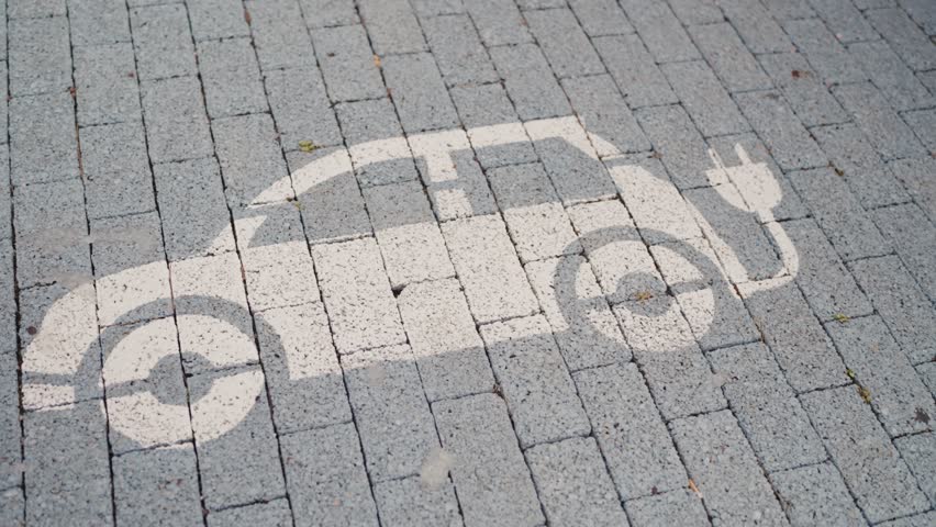 a stencil of an electric car is painted on a brick sidewalk . High quality