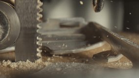 Slow motion 4k Video of an electric saw going thru wood and sawdust and wood chips flying away