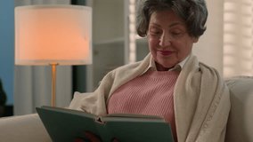 Happy inspired Caucasian old woman senior mature lady relaxed calm elderly female retired middle-aged granny pensioner grandmother alone at home couch reading book enjoy read novel literature relaxing - Powered by Shutterstock - Get 15% off with code: PIKWIZARD15