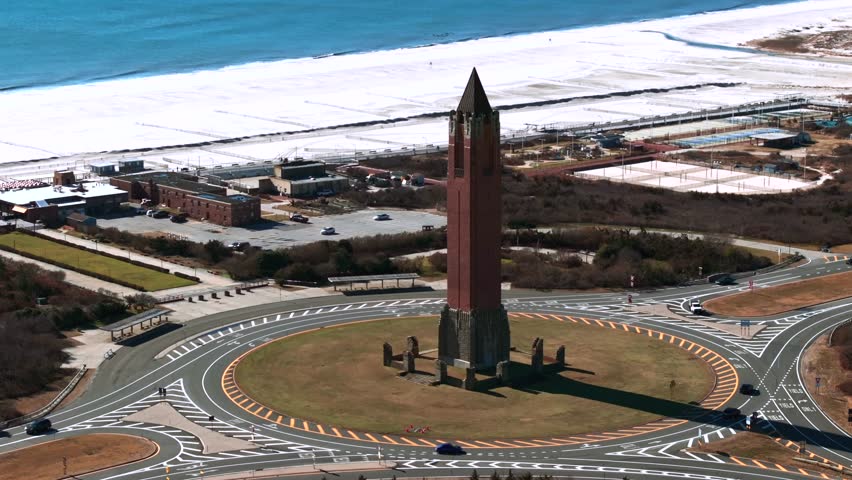 An aerial view of the water tower, known as the pencil at Jones Beach on Long Island, NY. Taken on a sunny day. The drone camera truck left and pan right orbiting the structure, then dolly in slowly.