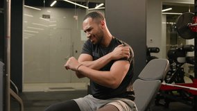 Latino ethnic multiracial American strong man sitting in gym press lift dumbbells up heavy metal equipment workout fitness exercise feel pain ache in shoulder guy male athlete bodybuilder sport injury - Powered by Shutterstock - Get 15% off with code: PIKWIZARD15