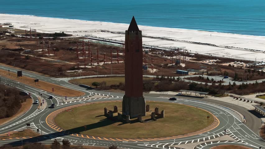 An aerial view of the water tower, known as the pencil at Jones Beach on Long Island, NY. Taken on a sunny day. The drone camera truck left ad pan right flying around the tower.