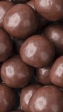 Vertical video. Closeup of chocolate malted balls. Candy backdrop.