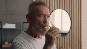 Sick ill old Caucasian man drink remedy vitamin complex in morning middle-aged senior mature male pensioner medicine treatment drug painkiller at home drinking water remedy dose medical supplement - Powered by Shutterstock - Get 15% off with code: PIKWIZARD15