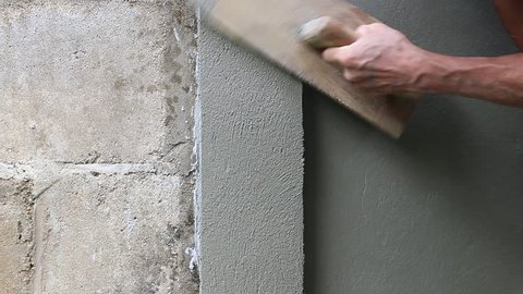 hand of Construction worker is plastering wall and beam using cement plaster at the construction site 