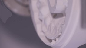 Vertical video. Close up. A professional CNC dental milling machine produced the shape of the artificial teeth. The concept of the work of a dental technician in a dental laboratory.