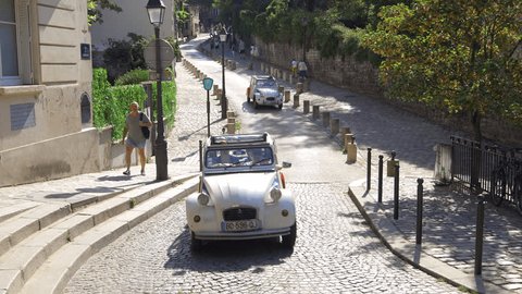 Paris, France - September 10, 2023 : Two 2CV Citroen vintage French cars driving in a street of Montmartre district in Paris, France Video Stok Editorial