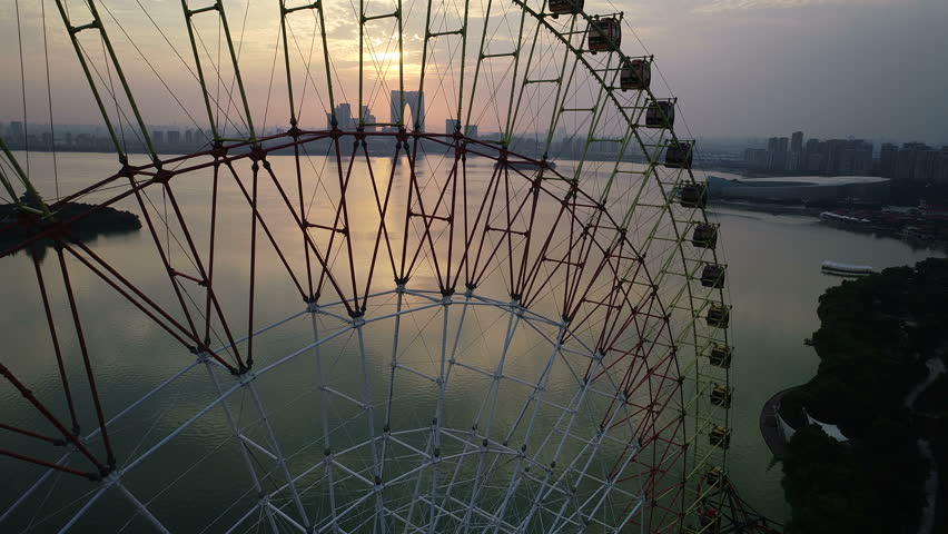 Drone flight past ferris wheel reveals beautiful Jinji lake and panoramic skyline of Suzhou city in China
