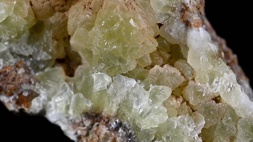 Greenish yellow Smithsonite (zinc carbonate) crystals rotating slowly against a black background
