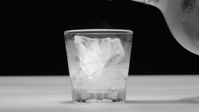 Close-up of a drink being poured over ice cubes in a glass, against a dark background - Powered by Shutterstock - Get 15% off with code: PIKWIZARD15