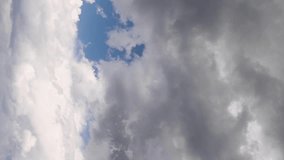 Vertical video nature background time lapse for social media of white fluffy storm clouds moving across a blue sky