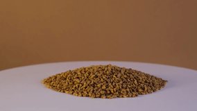Heap of Fenugreek Seeds or Shambhala or helba. Trigonella foenum-graecum seeds used in food, drink and alternative medicine. Ayurvedic food. 4K video, Rotating.