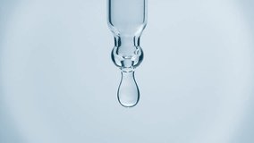 Cosmetics blue liquid dripping from laboratory glass pipette in super slow motion. Macro shot of drop hanging down from chemical dropper. Abstract body care serum ingredients formulating concept - Powered by Shutterstock - Get 15% off with code: PIKWIZARD15