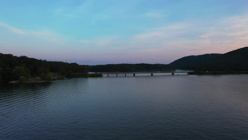 Forwards fly above water surface, heading towards road bridge over Lake Allatoona. Atlanta, Georgia, USA