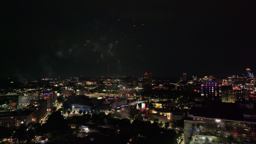Forwards fly above night city. Beautiful fireworks above public park in urban borough. Atlanta, Georgia, USA Royalty-Free Stock Footage #3442267159