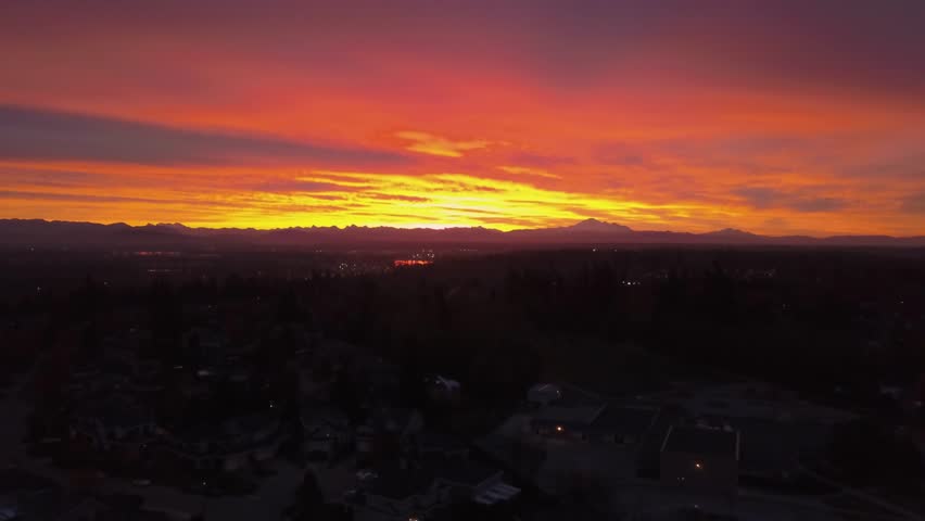 Aerial view on the residential homes in a suburban city area during a vibrant and colorful sunrise. Taken in Greater Vancouver, British Columbia, Canada.